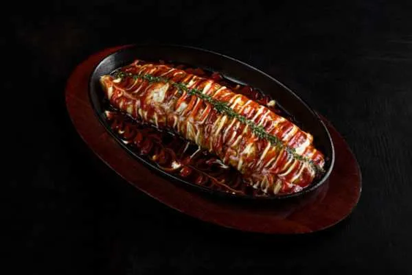 Okonomiyaki served on a hot cast-iron plate