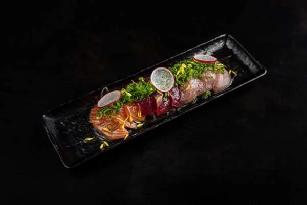 Sashimi arranged on a long black plate