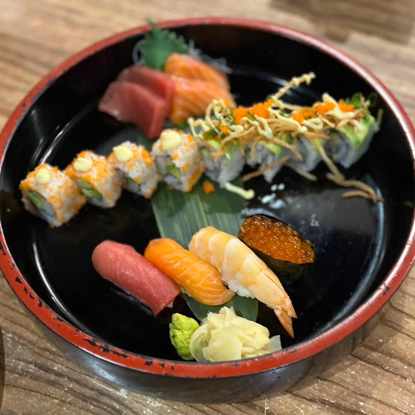 Assorted sushi and rolls in a black lacquer bowl