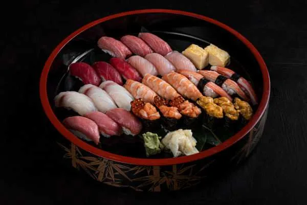Large round lacquer platter of assorted nigiri sushi