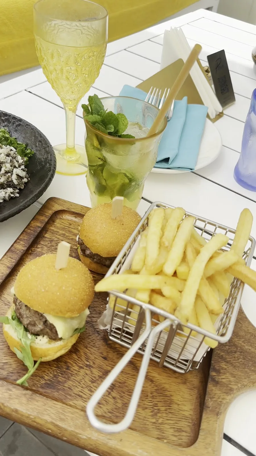 Wagyu-style sliders with crinkle fries and a fresh mojito on a sunlit table
