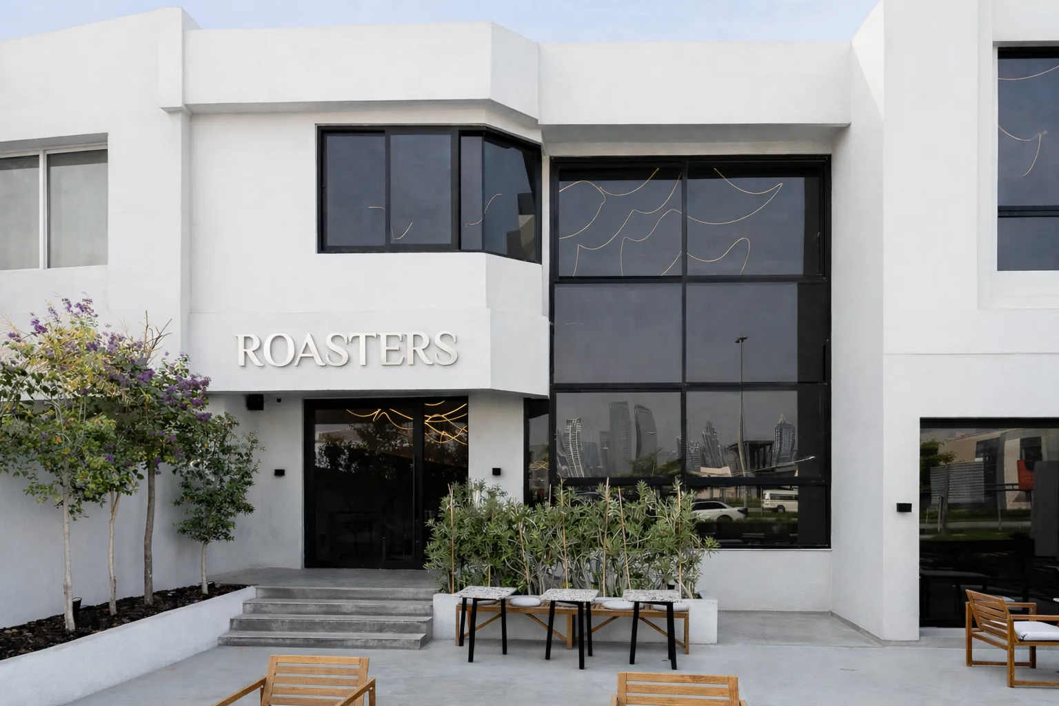 Roasters Specialty Coffee House villa on Al Wasl Road with the Dubai skyline reflected in its glass façade