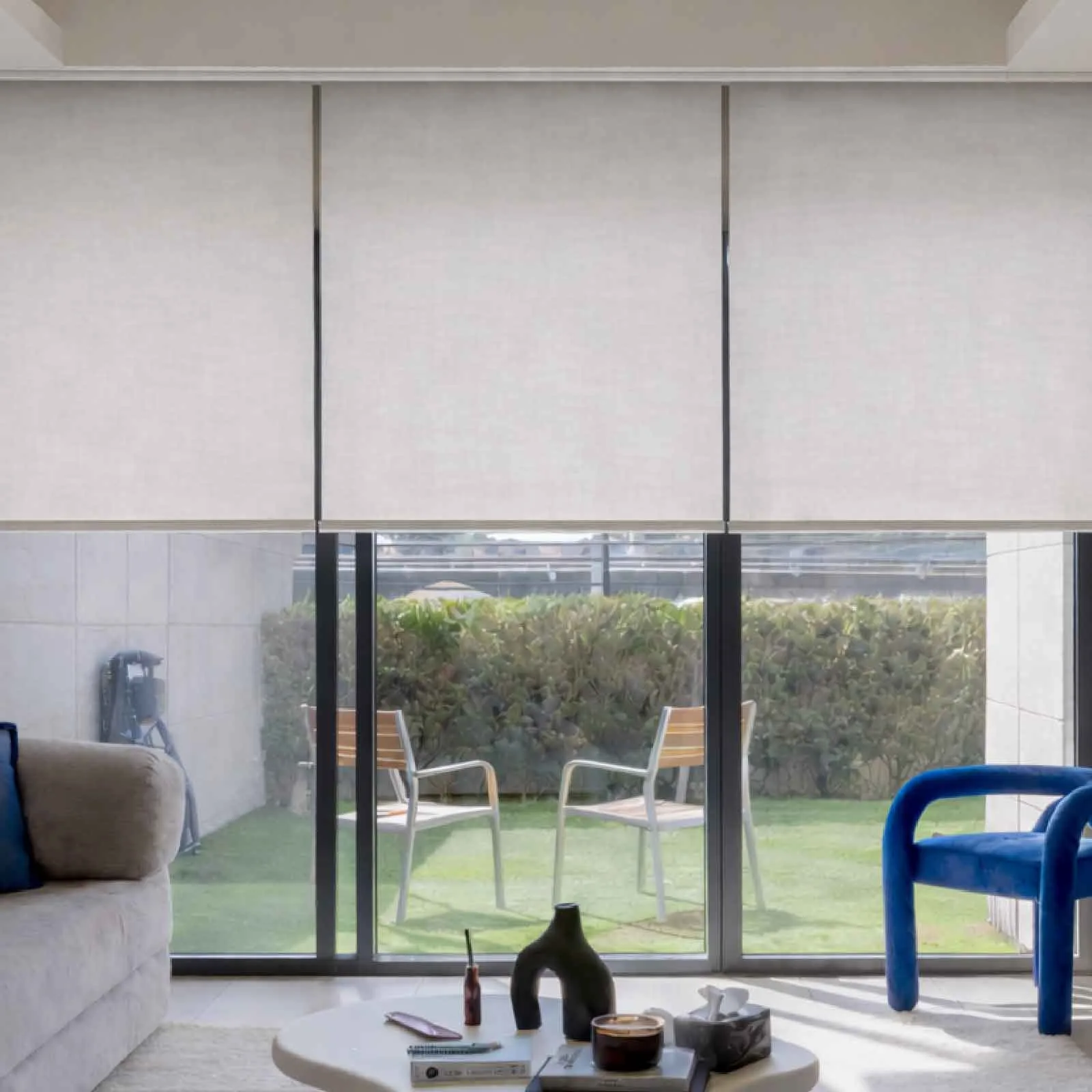 Roller blinds across a wide living-room window