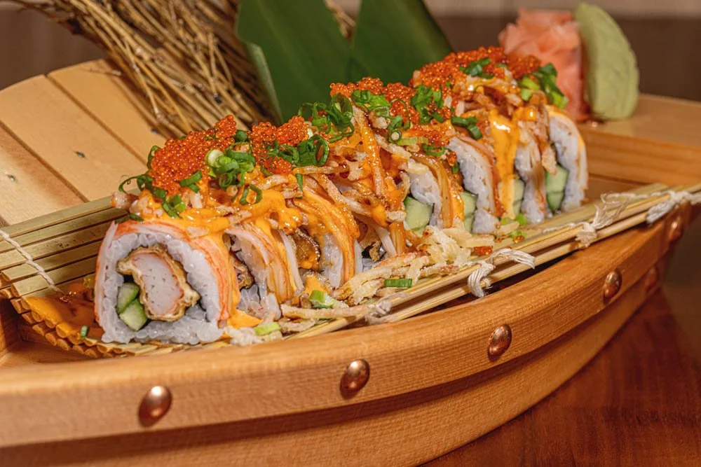 Close-up of a Mogi-ya signature sushi roll on a wooden boat