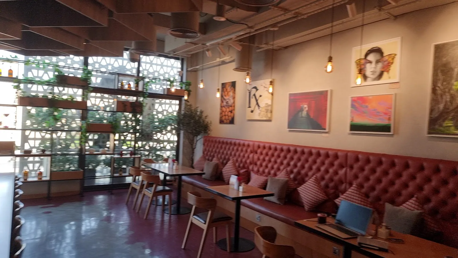 Red leather banquette below a wall of framed art