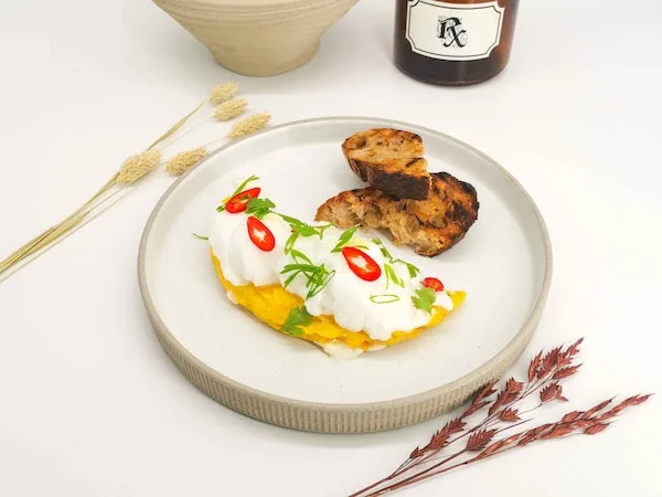 A plated egg dish beside an Rx bottle