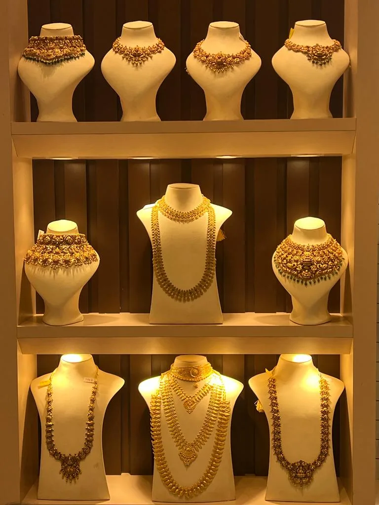 Lit display shelves of gold jewellery