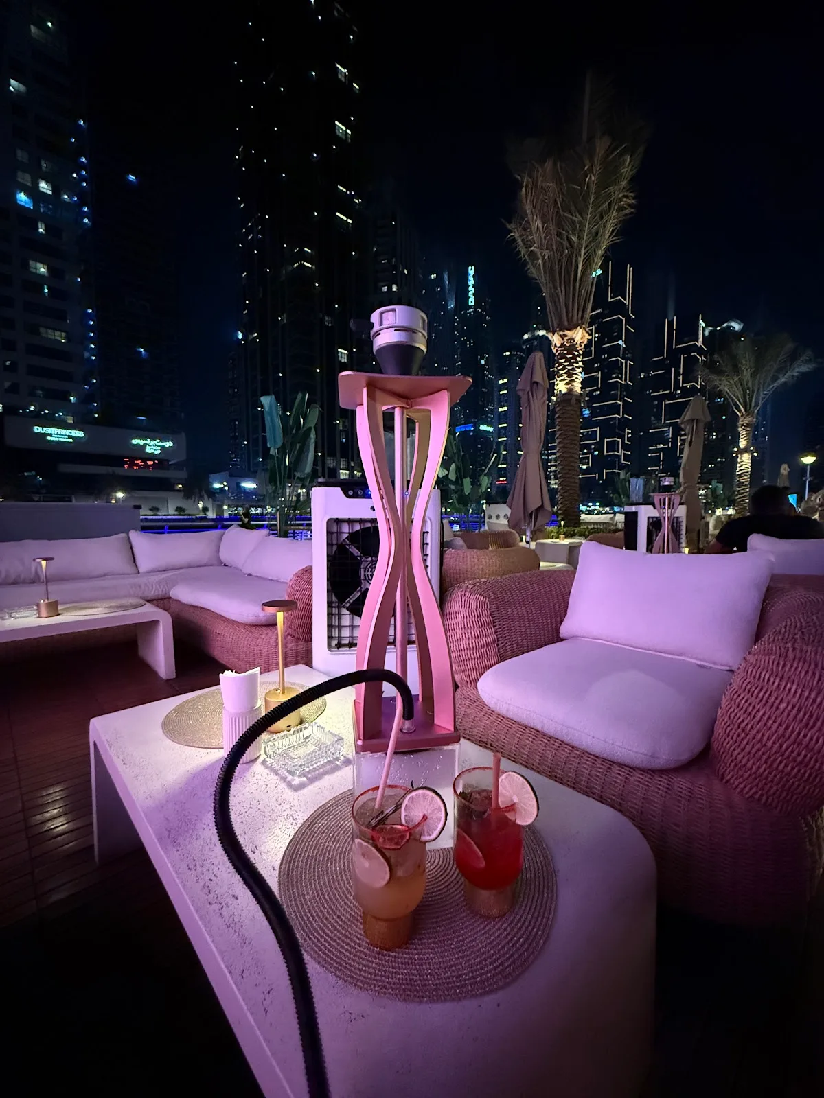 Terrace lounge seating at La Letizia glowing at night with the marina behind