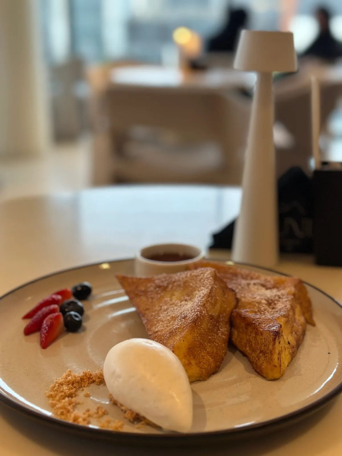 Golden French toast dusted with sugar, served with ice cream and berries.