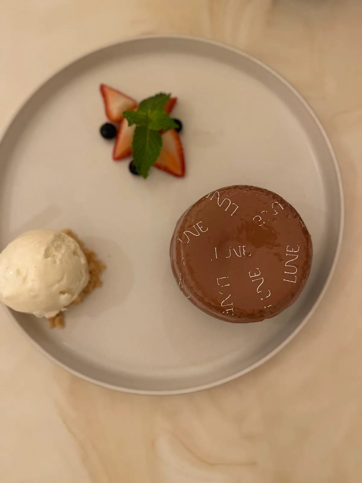 A glazed chocolate dessert embossed with LUNE.