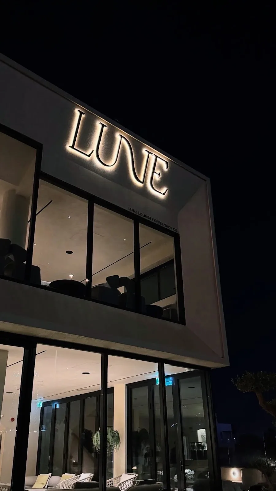 The glowing LUNE sign at night.