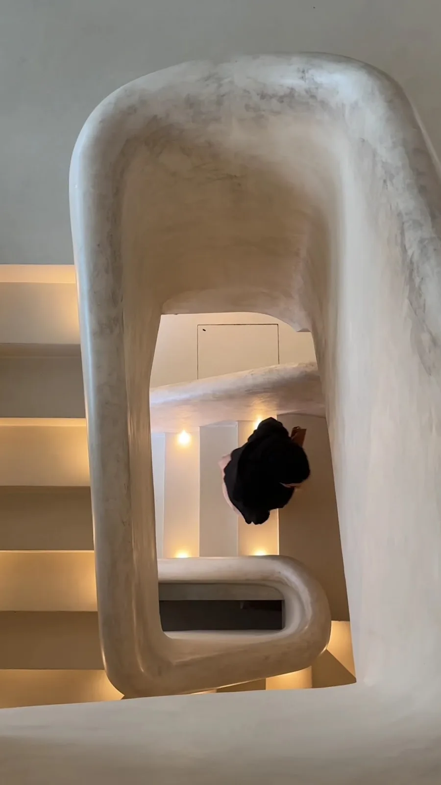 Lune Lounge's sculptural white plaster staircase curving between floors.