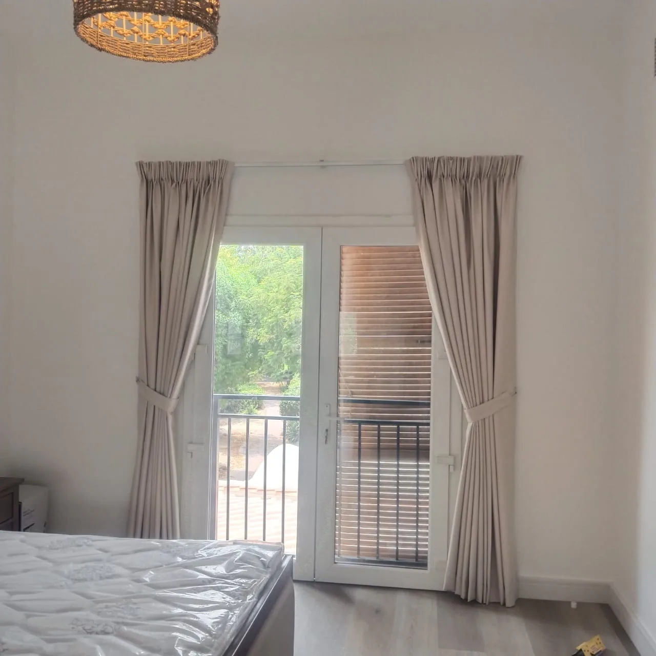 Neatly fitted pinch-pleat curtains around a balcony door in a Dubai apartment