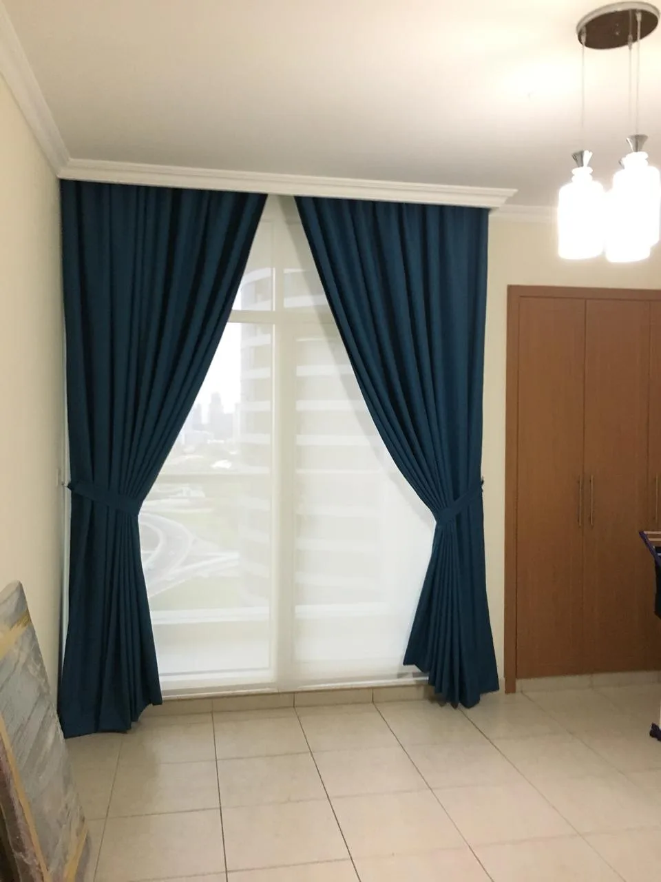 Tailored teal curtains with tie-backs and a pelmet in a Dubai apartment