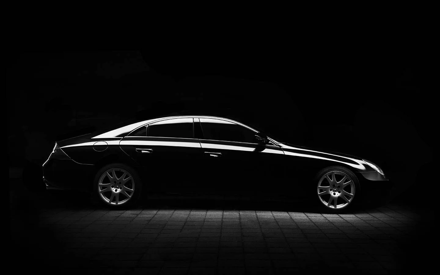A detailed dark sedan under dramatic studio lighting