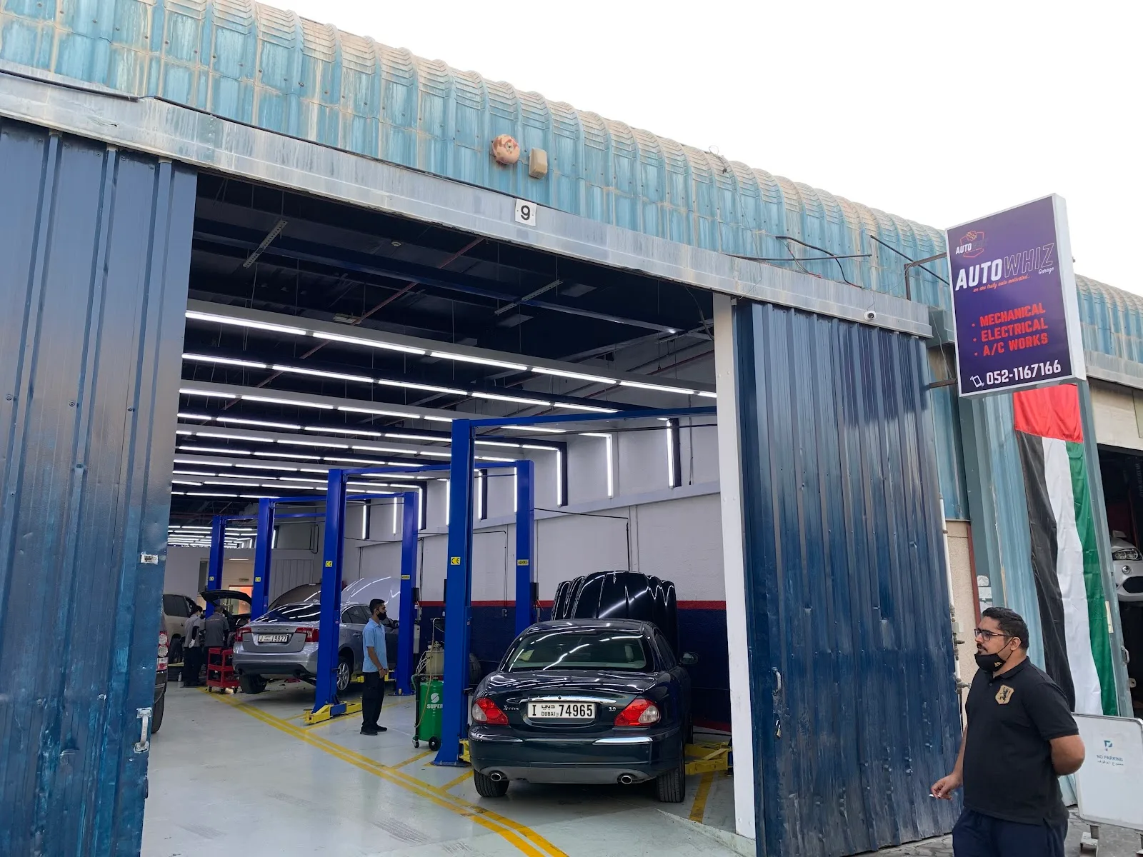 Auto Whiz Garage entrance with cars on lifts inside