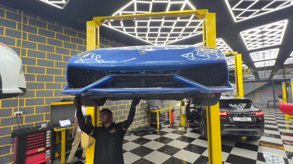 Blue Lamborghini lifted on a two-post hoist