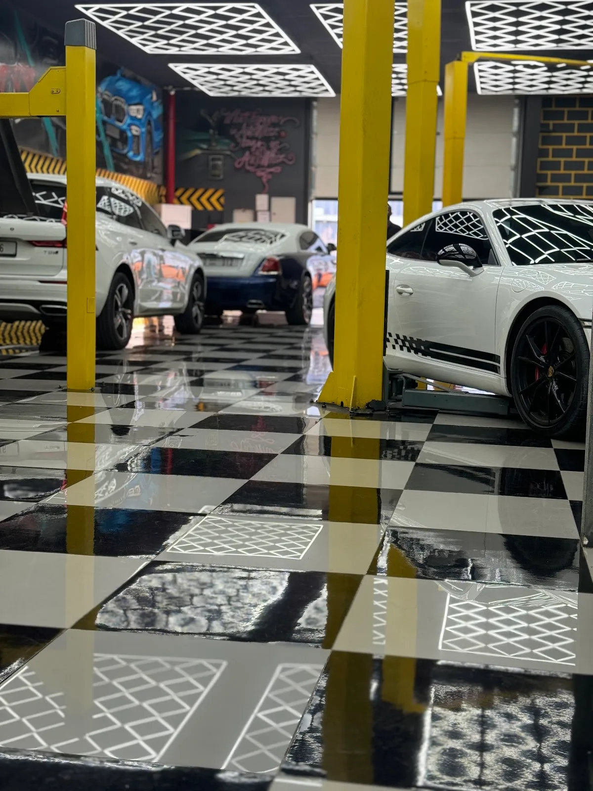 White Porsche on a glossy checkered workshop floor