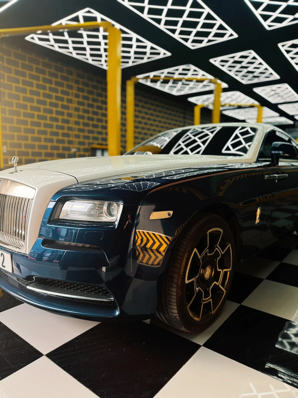 Dark blue Rolls-Royce Wraith parked on the checkered floor