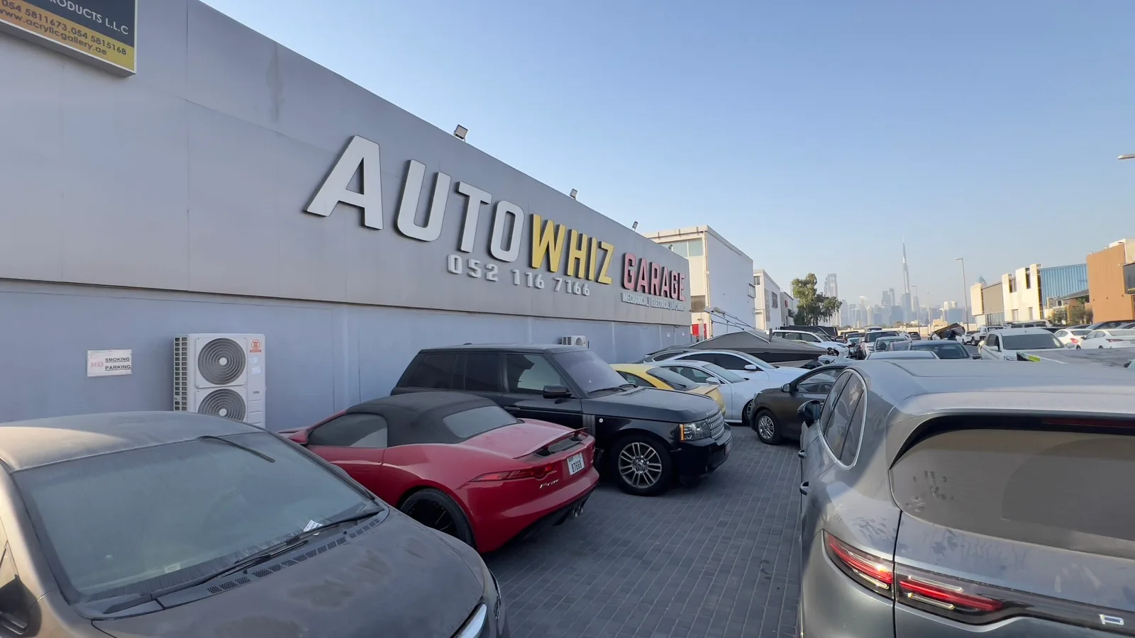 Auto Whiz Garage signage with the Dubai skyline in the distance