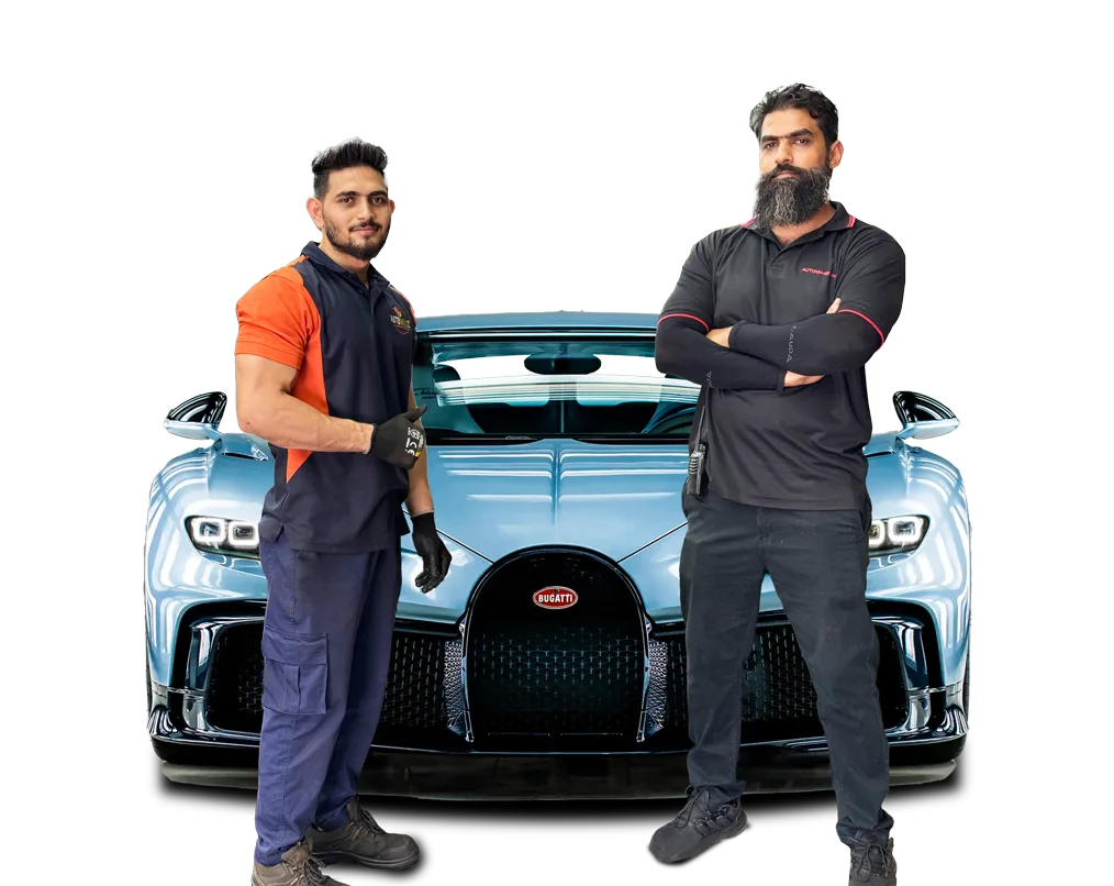 Two Auto Whiz Garage technicians standing in front of a light-blue supercar