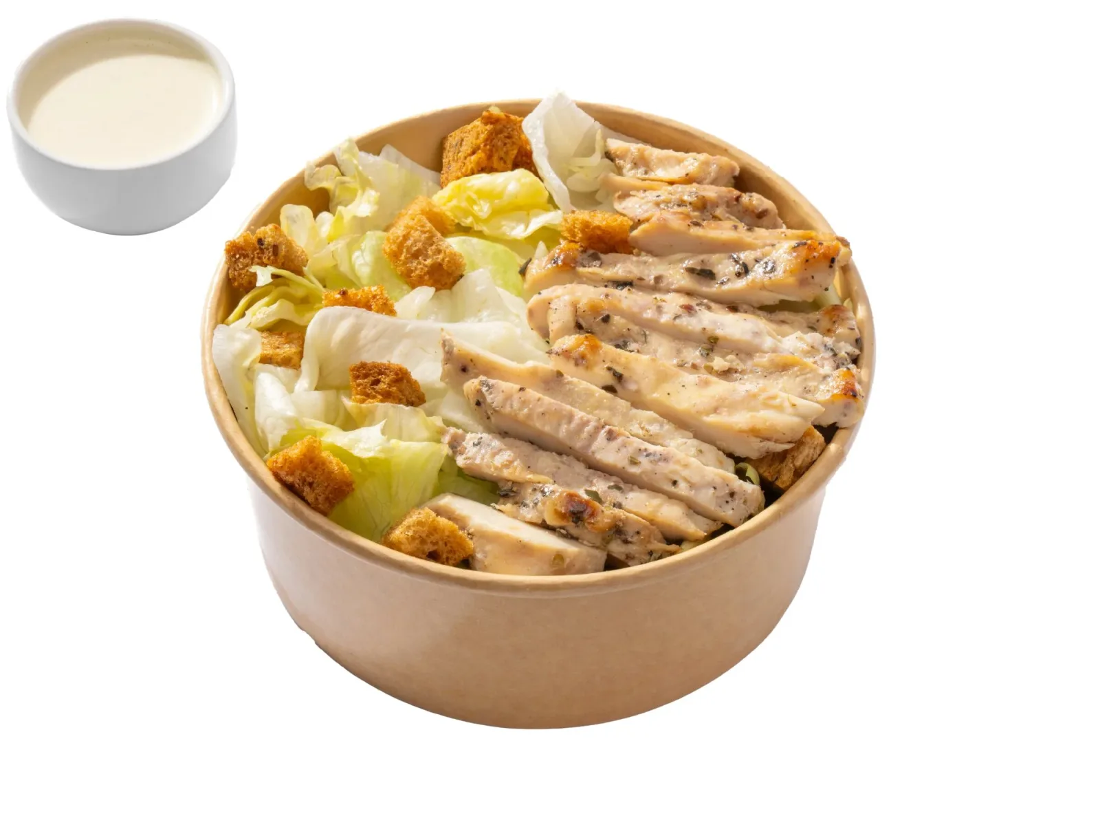 Chicken Caesar salad in a kraft bowl with dressing on the side