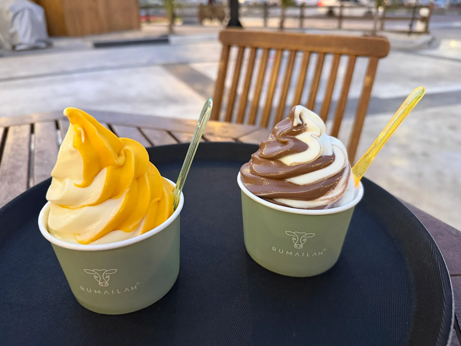 Two cups of soft-serve gelato on an outdoor table