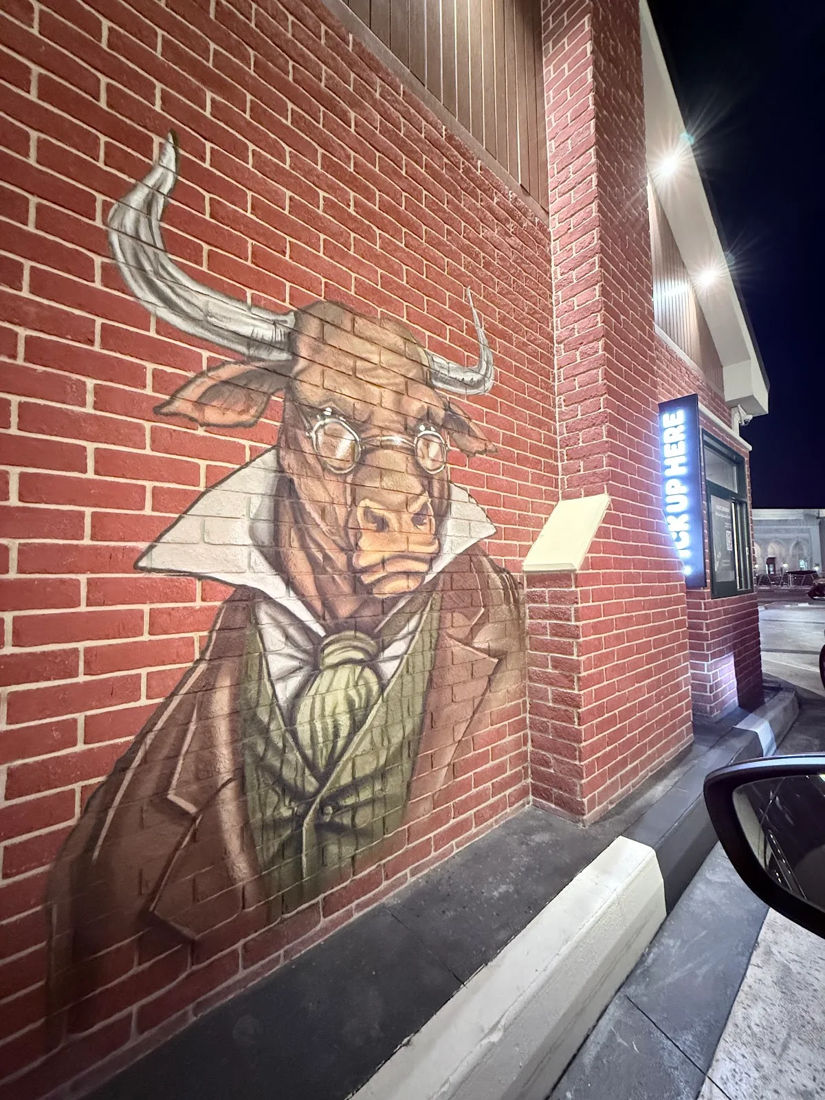 Mural of a bull in a suit beside the pick-up window