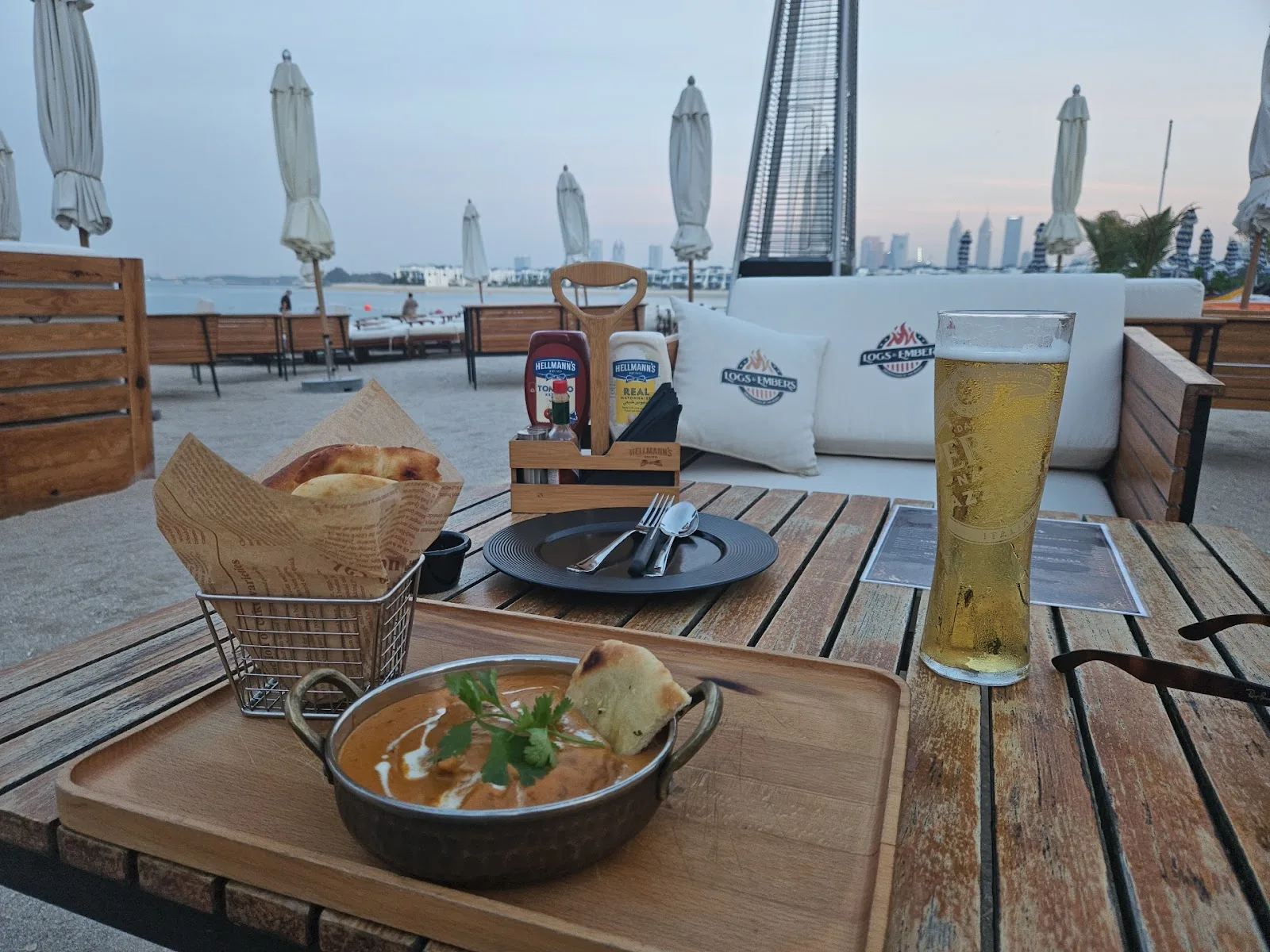 Curry and bread served beachside with a cold beer and sea view