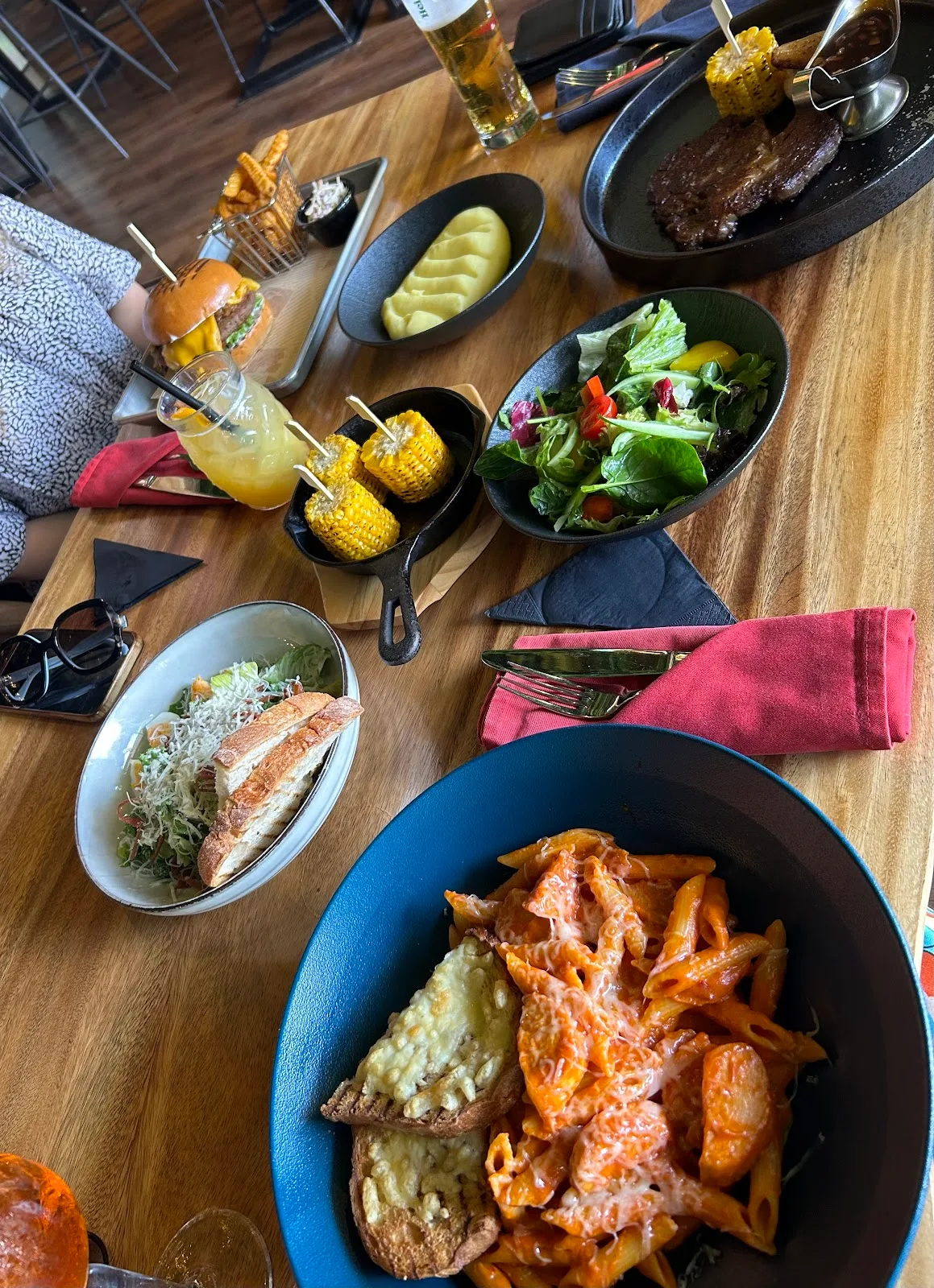 Overhead spread of dishes, sides and drinks on a wooden table
