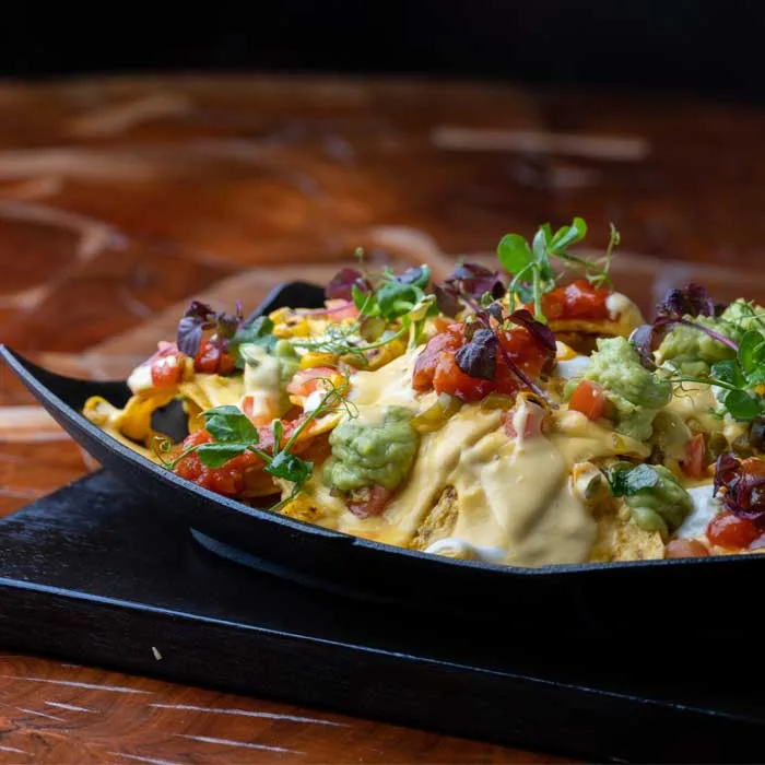 Loaded nachos with melted cheese, guacamole and salsa