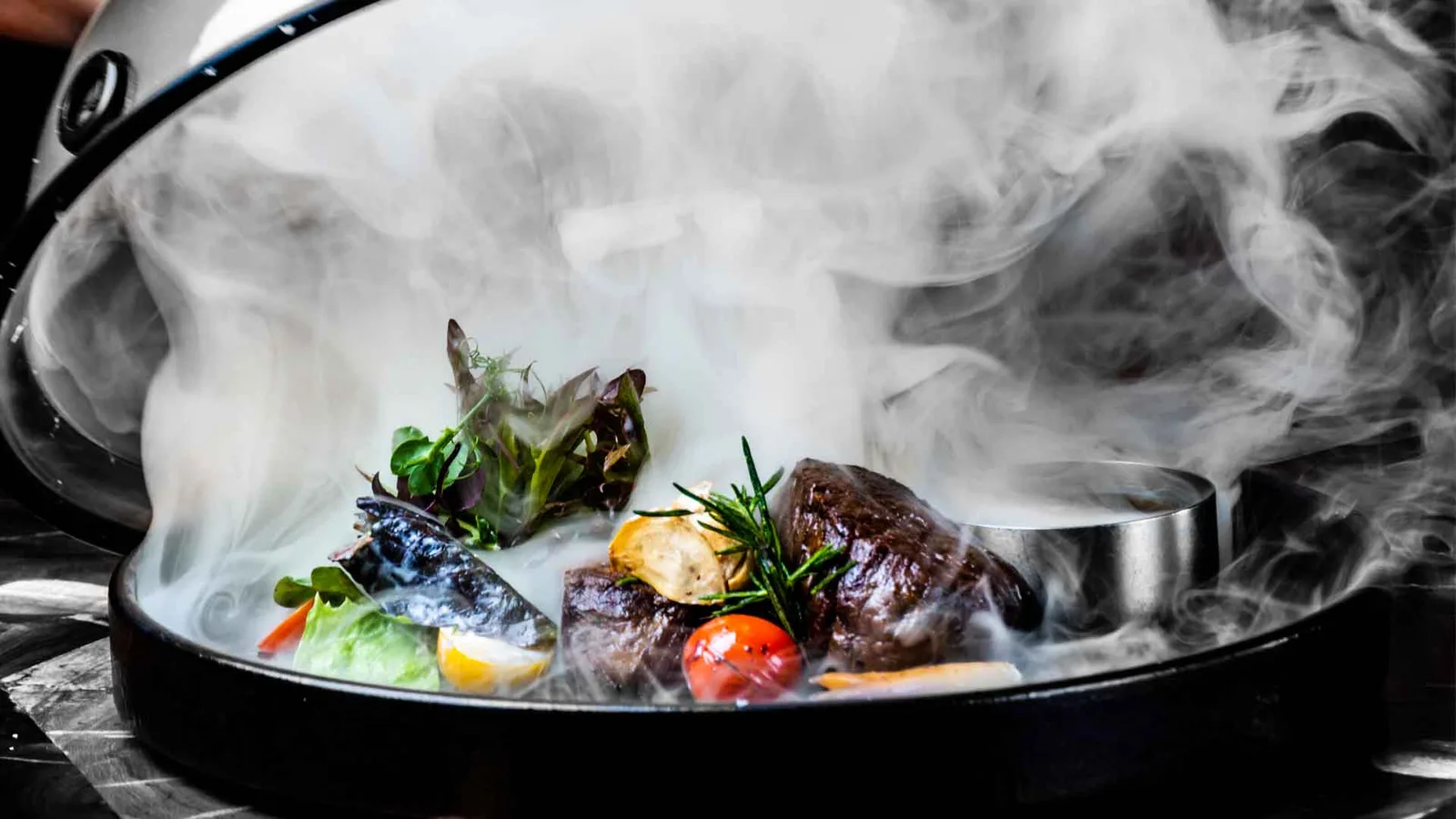 Smoked steak revealed under a cloud of smoke