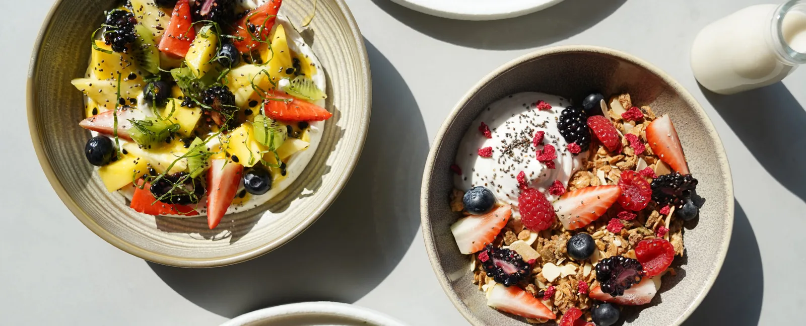 Fruit bowl and yoghurt granola bowl with berries