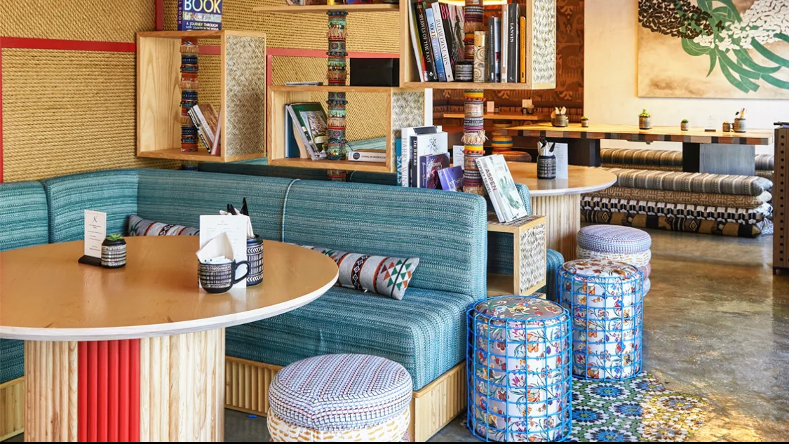 The book-lined reading nook with a teal banquette.