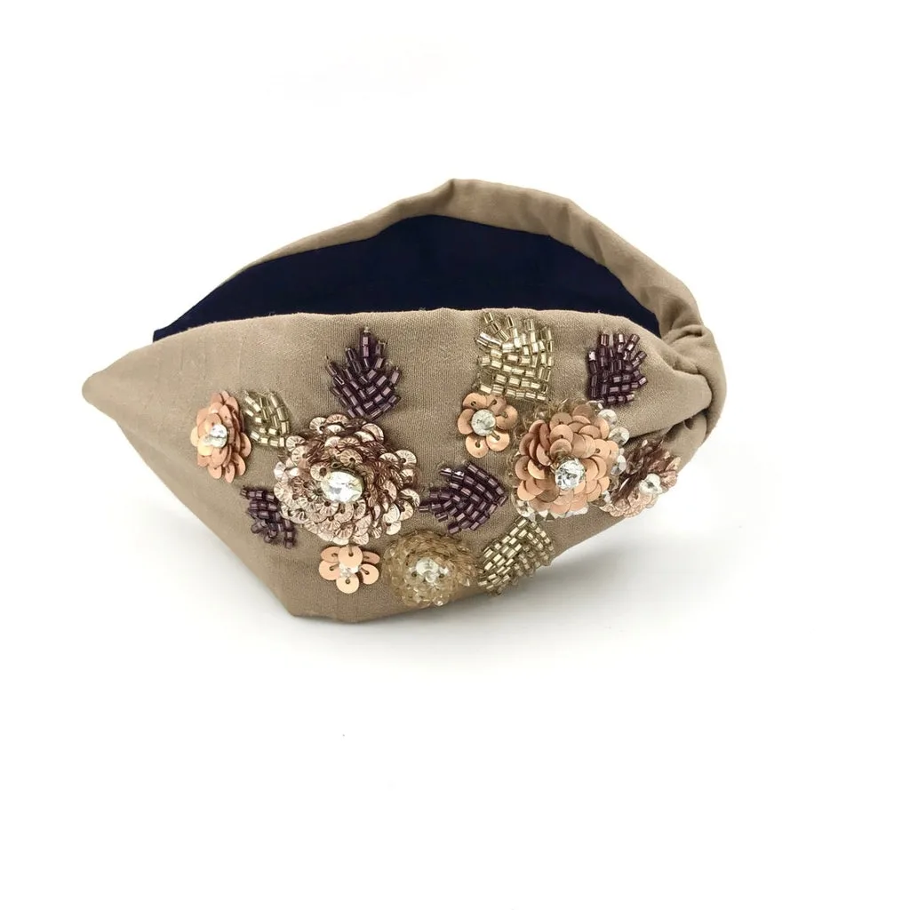 A beaded and sequinned floral headband in soft neutrals.