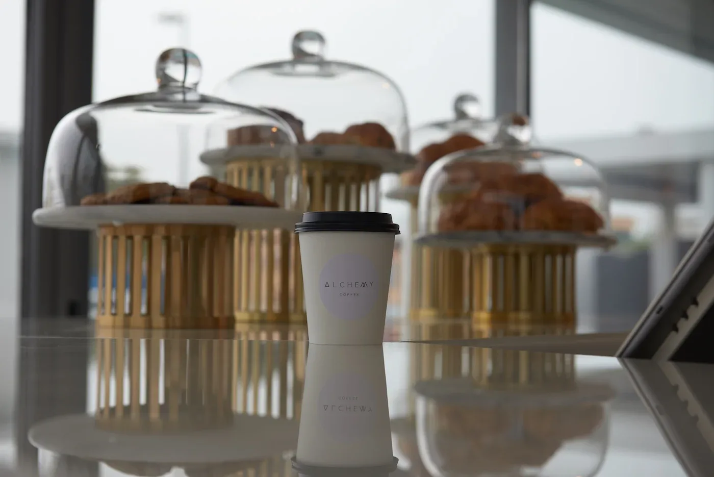 Pastries under glass cloches with an Alchemy cup
