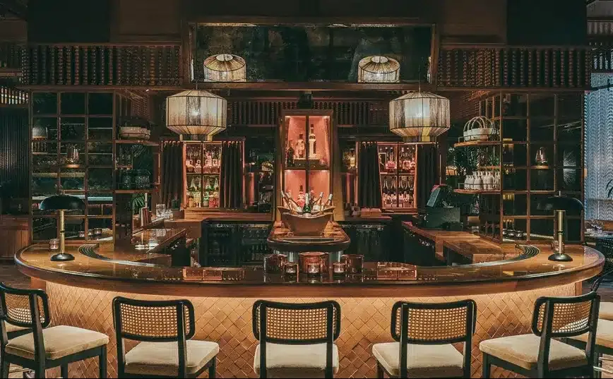 The curved central bar at Mimi Kakushi under woven pendant lamps