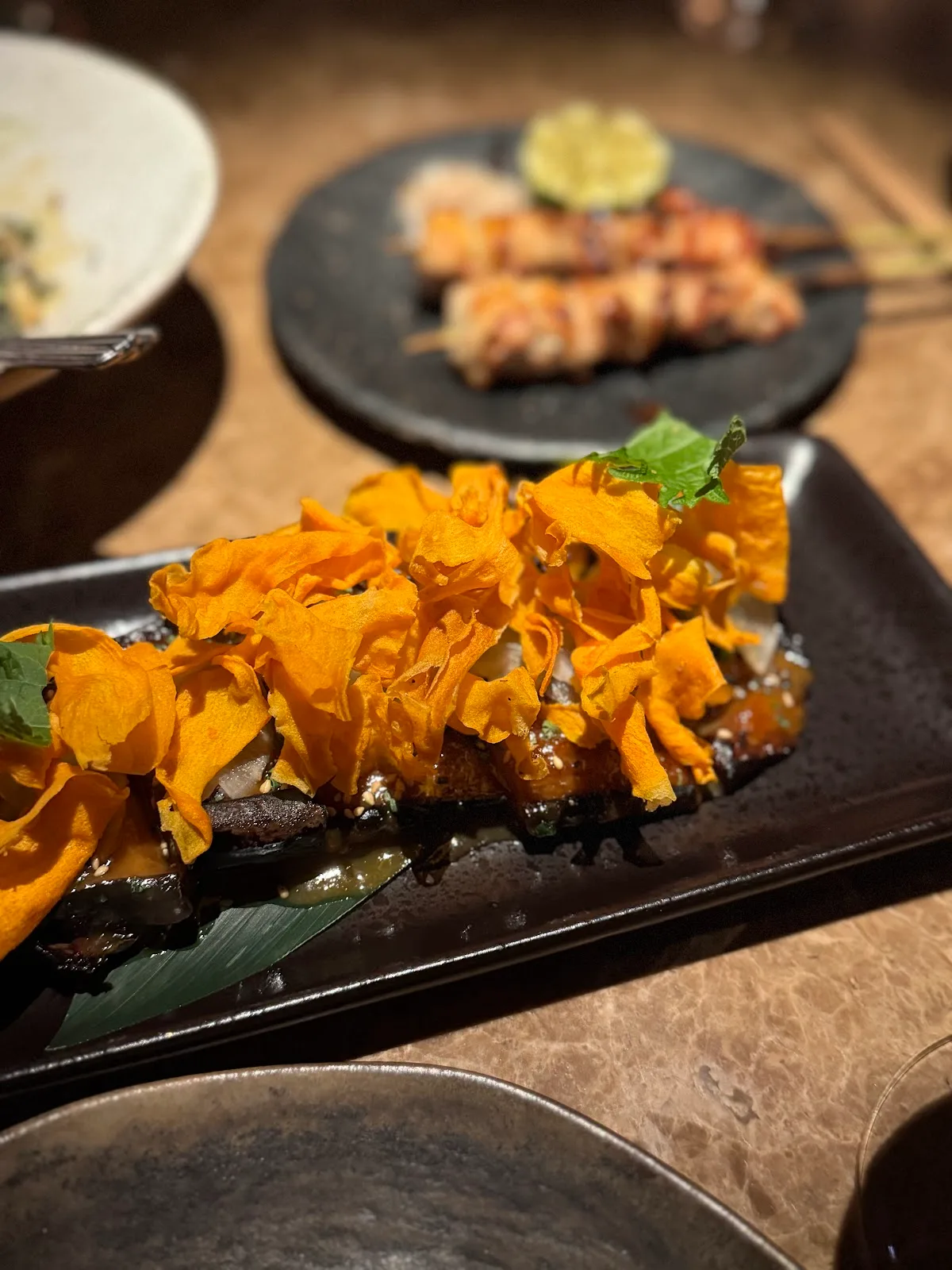 A grilled dish topped with crisp vegetable shavings