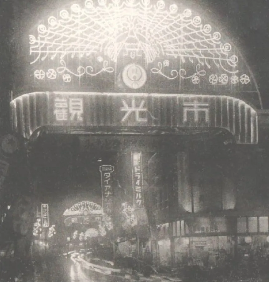 Vintage black-and-white photograph of a neon-lit street at night