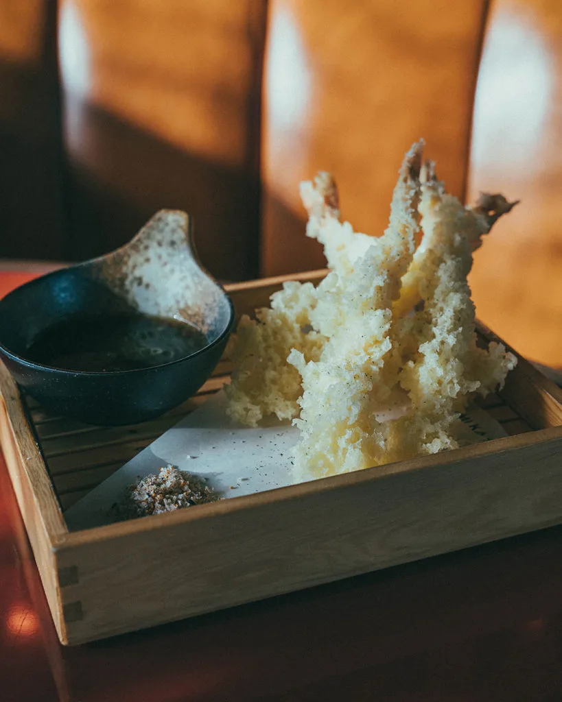 Tempura served in a wooden box with dipping sauce