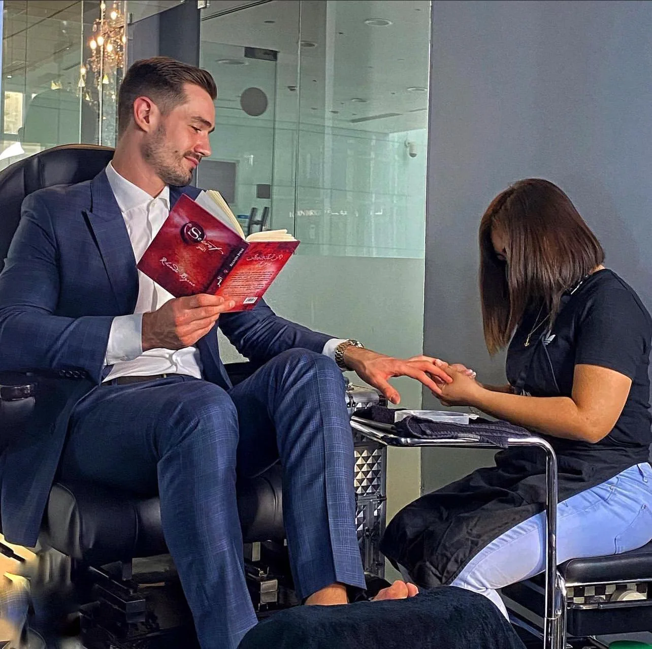 A guest relaxing with a book during a manicure