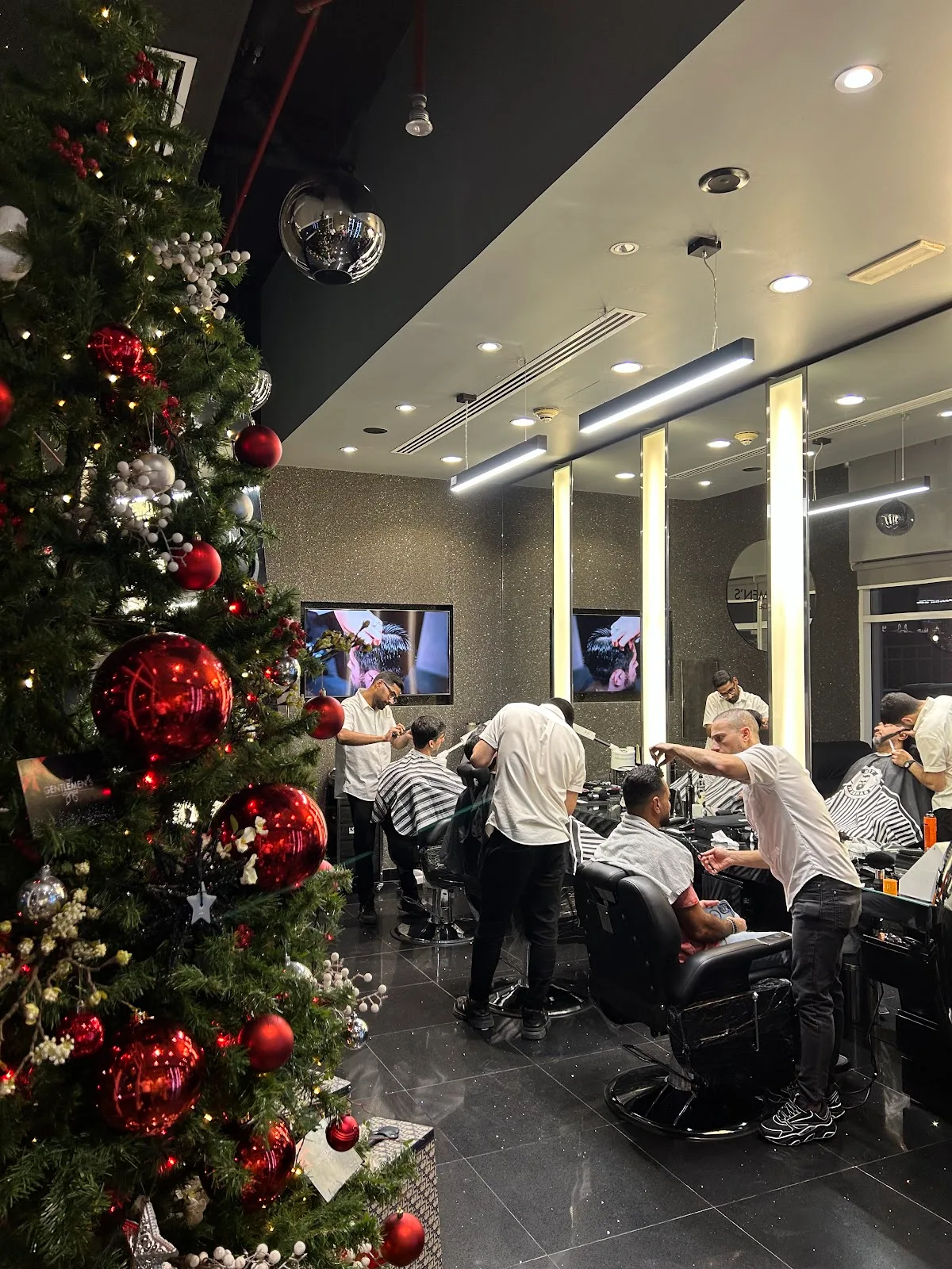 Barbers at work across a full floor at The Gentlemen's Barber Shop - Dubai
