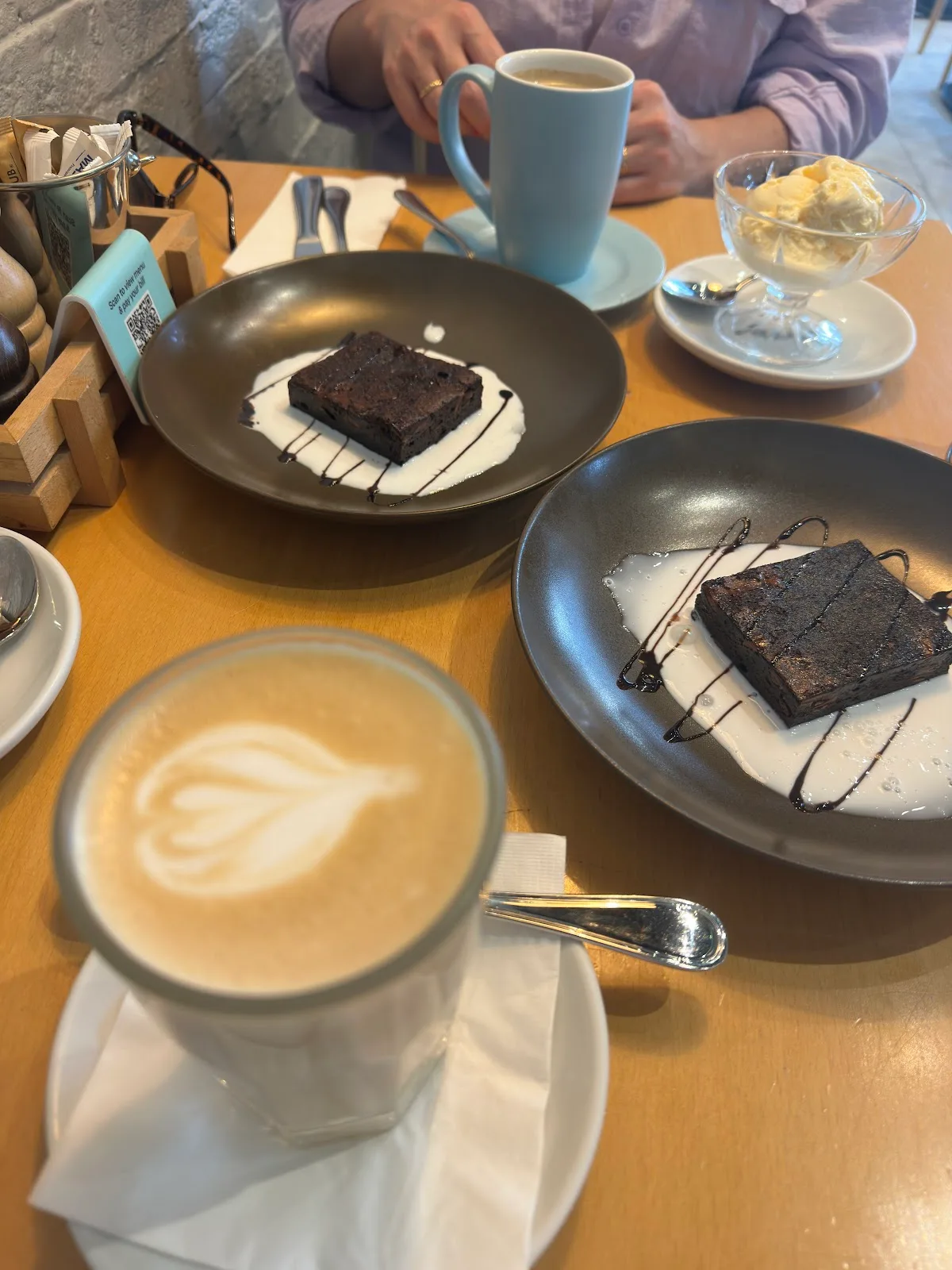 Chocolate brownies with ice cream and a latte on the table