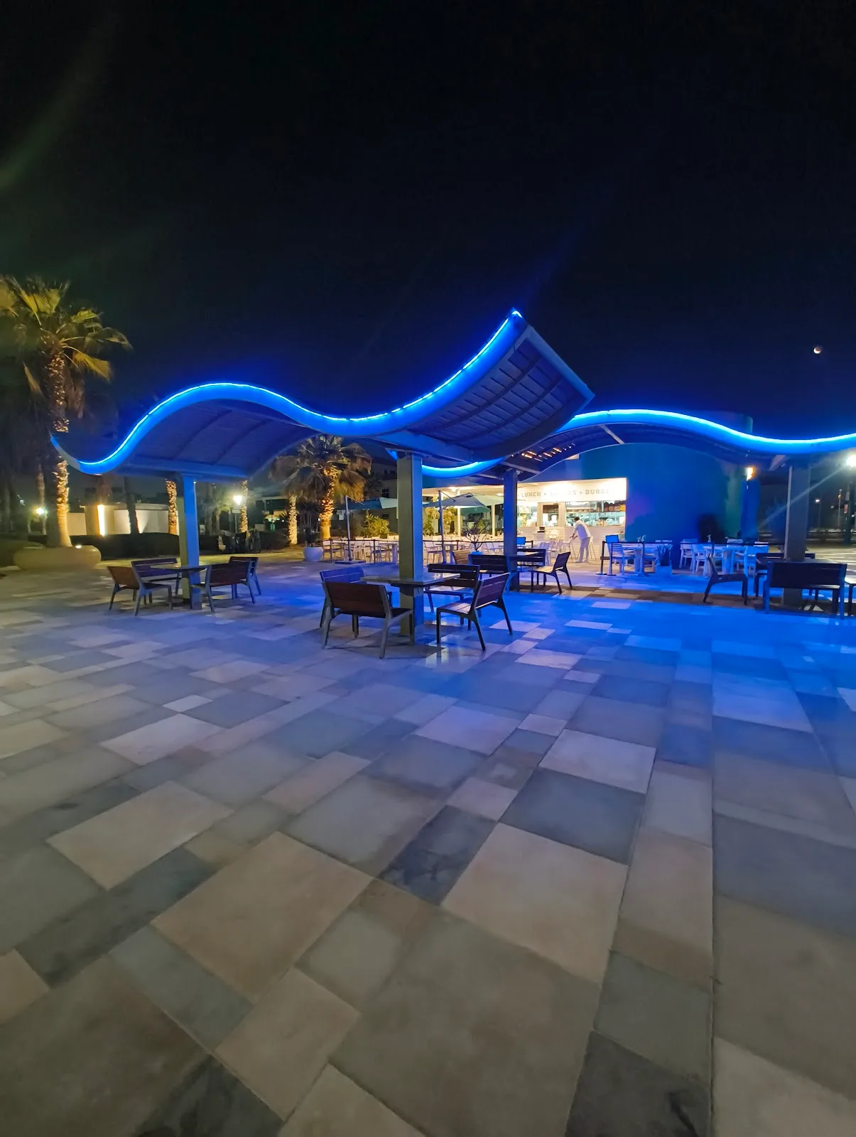 The beachfront seating area lit blue at night