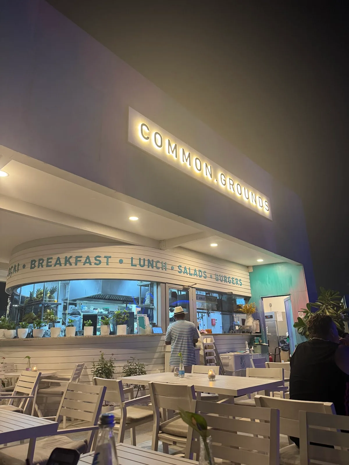 The Common Grounds sign glowing warmly at night