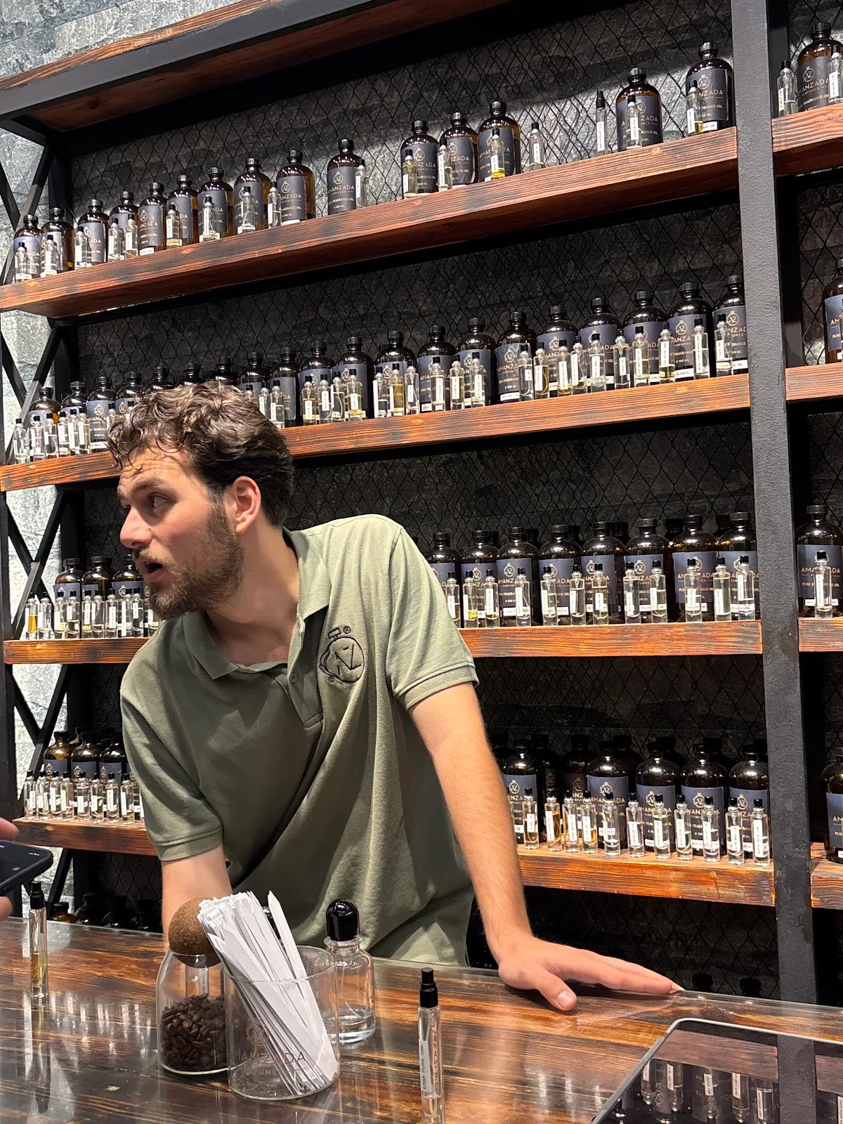 Staff member at the counter with the oil wall behind