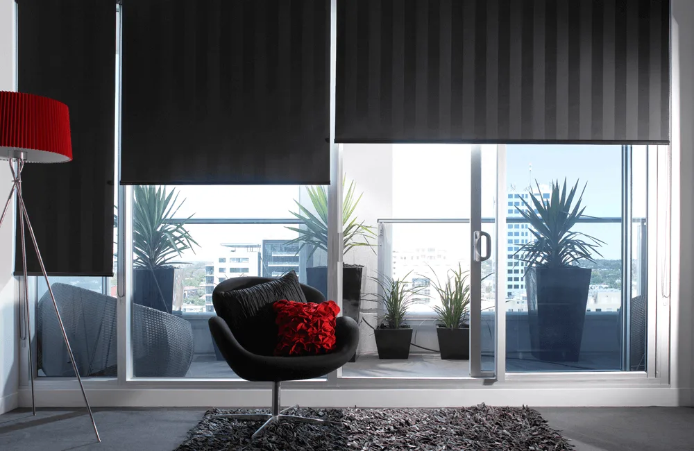 Black blackout roller blinds in a penthouse with city view