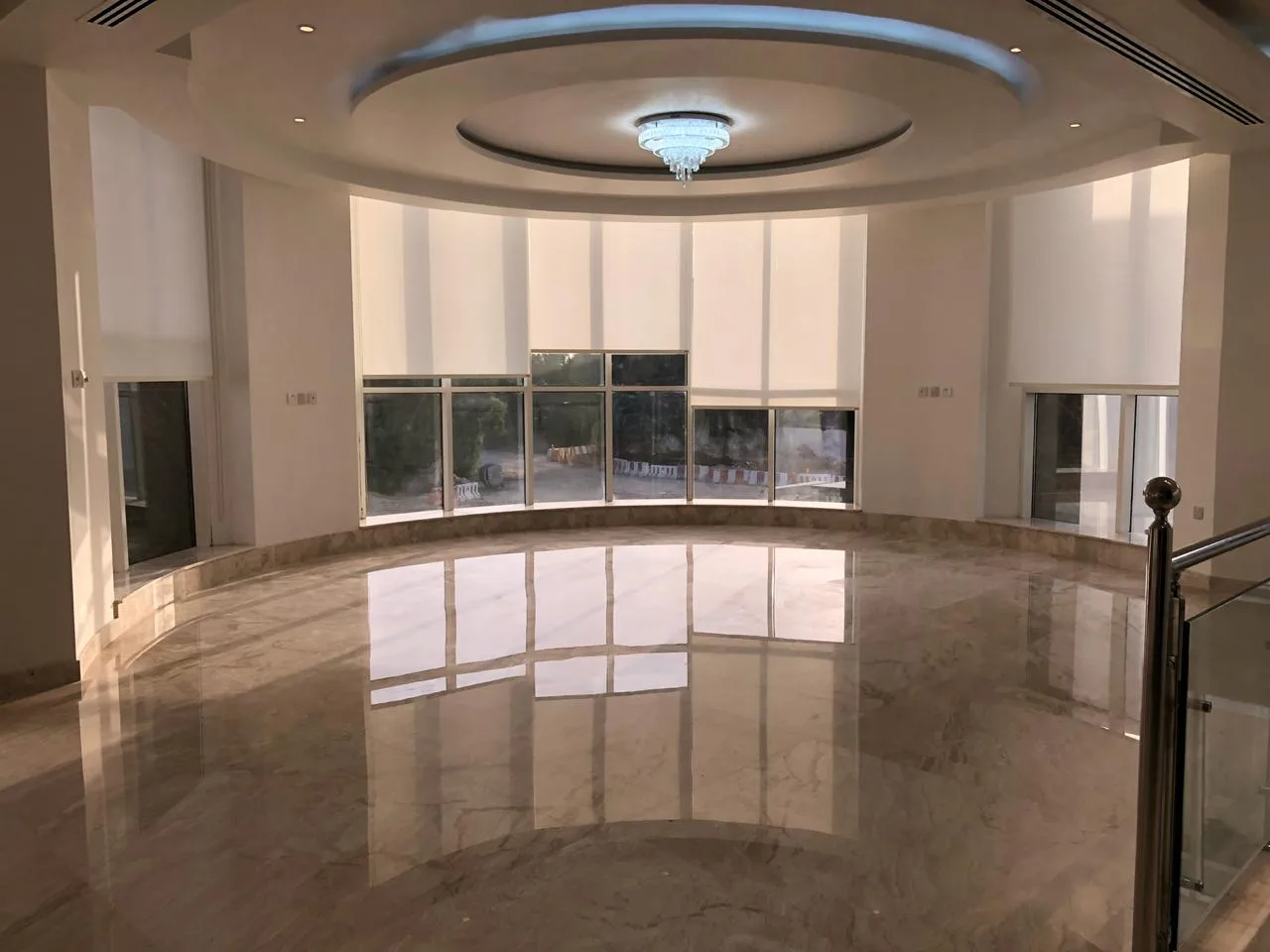 Roller blinds in a curved marble-floor villa room