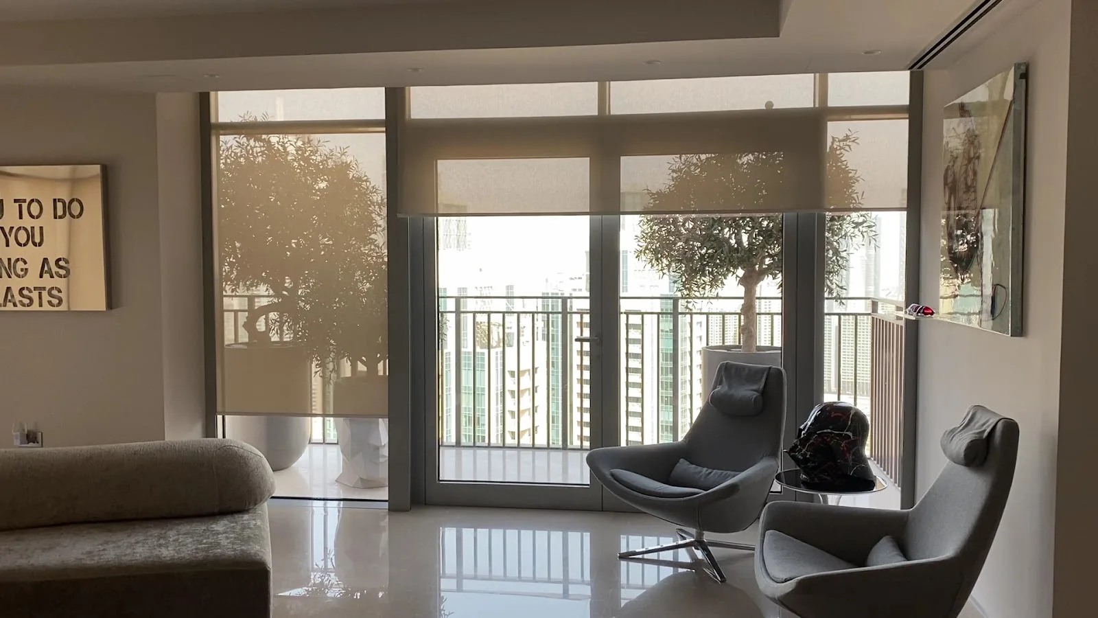 Grey roller blinds across full-height windows in a living room