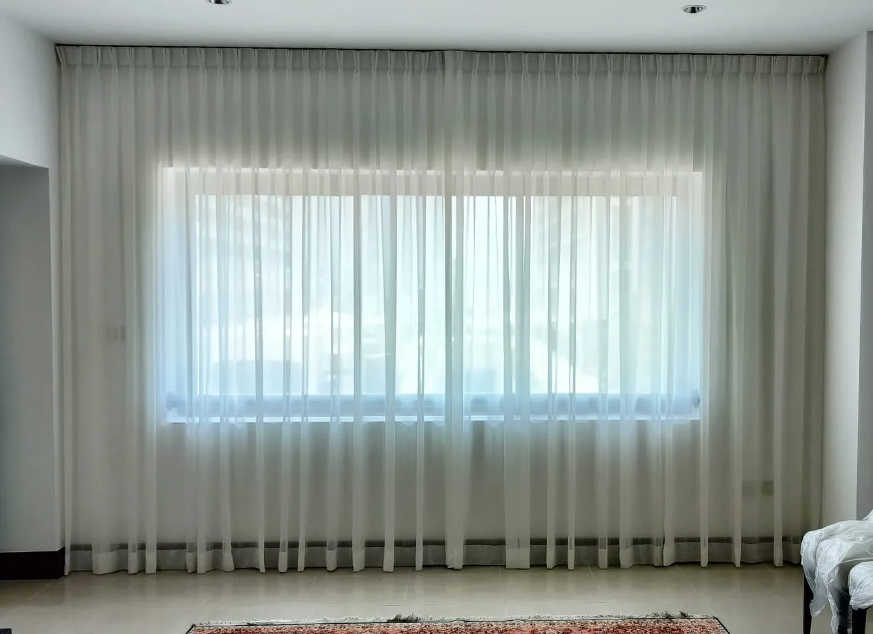Sheer voile curtains diffusing daylight across a wide window